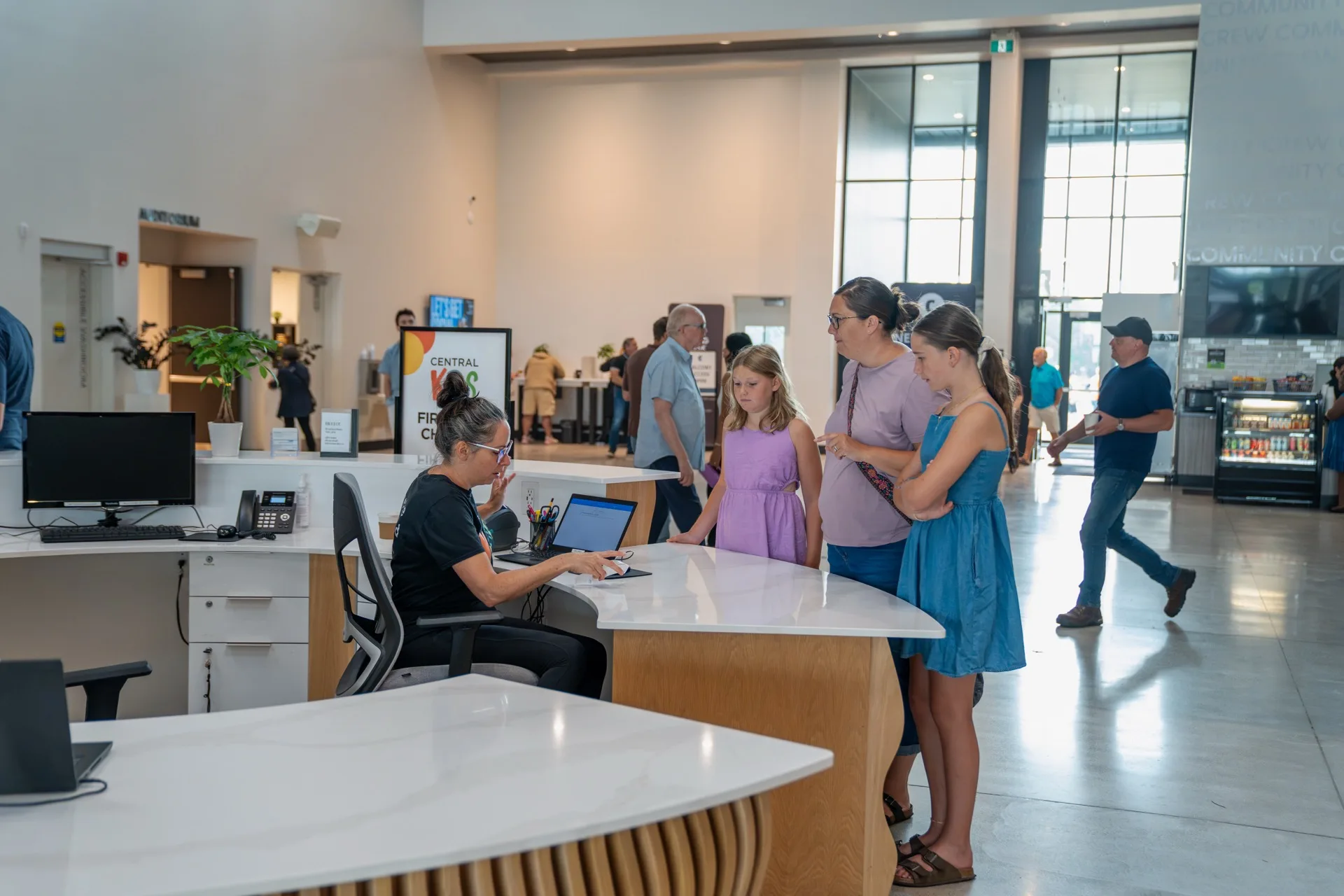 A family being helped at the welcome desk in the lobby on a Sunday morning.