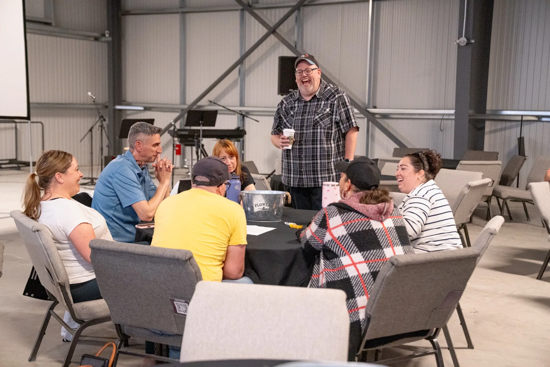 A group of adults sitting around a table talking together.